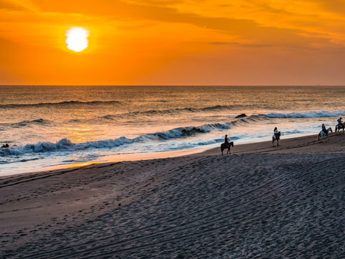 Four travelers take a luxurious sunset horseback ride along the beach in Nicaragua.