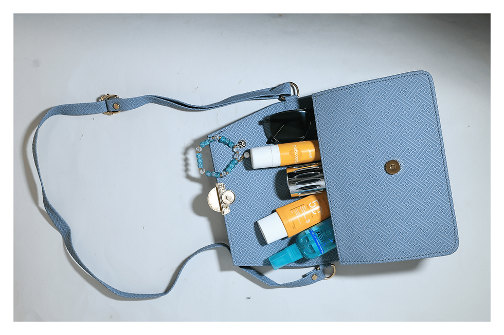 Open light blue luxury bag with sunscreen and sunglasses