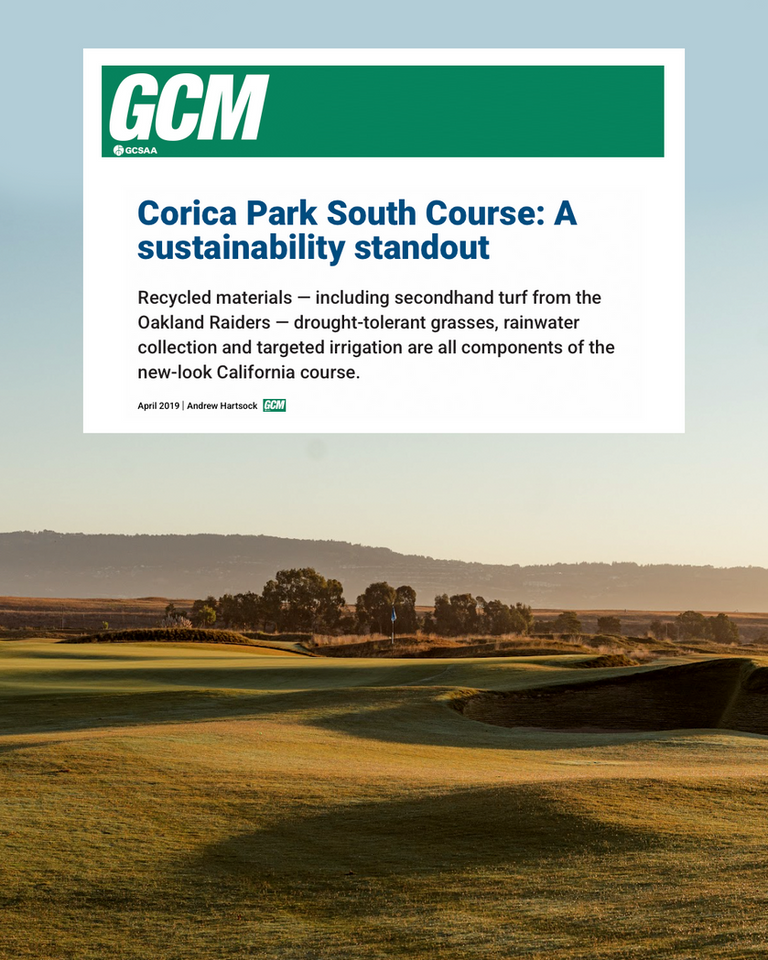 A green golf course with rolling hills and trees under a soft sunrise sky.