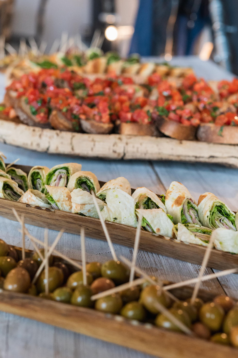 Bruschetta mit Tomaten, gefüllte Wraps und grüne Oliven auf Holzplatten – Fingerfood von 5P Streetfood