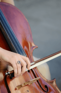 אישה מחזיקה קשת ומנגנת על צ'לו לכן יש לה כישרון מוזיקלי