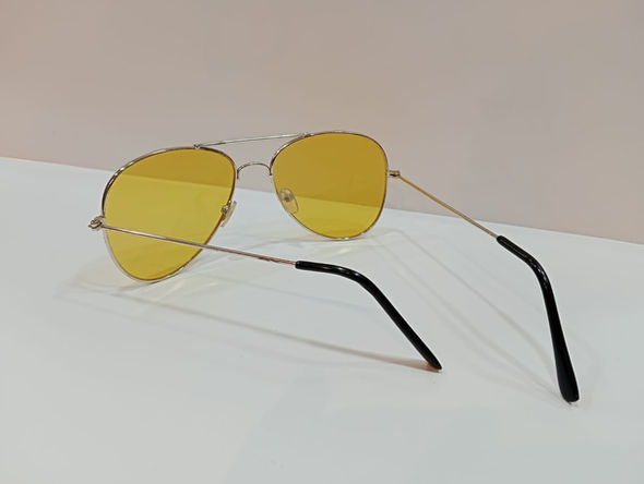 Stylish gold-framed aviator sunglasses with bright yellow lenses.