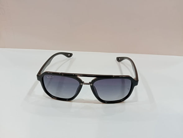 Black aviator-style sunglasses with gradient lenses on a white surface.