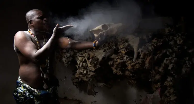 Spiritual guide blowing smoke in a ritual