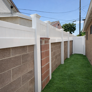 White vinyl privacy fence installation in San Diego backyard with palm trees 

