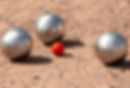 Partie de pétanque sur terre battue avec 3 boules OBUT et un petit cochonnet rouge-orangé