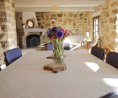 Salle à manger avec 5 chaise et des fleurs sur la table