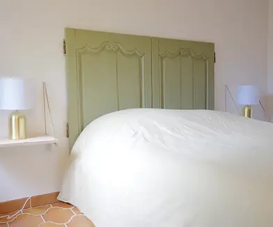 Lit avec lampes de chevet blanches et tête de lit verte