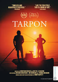 Wide-angle view of a tarpon rolling beside a flats skiff in the Florida Keys