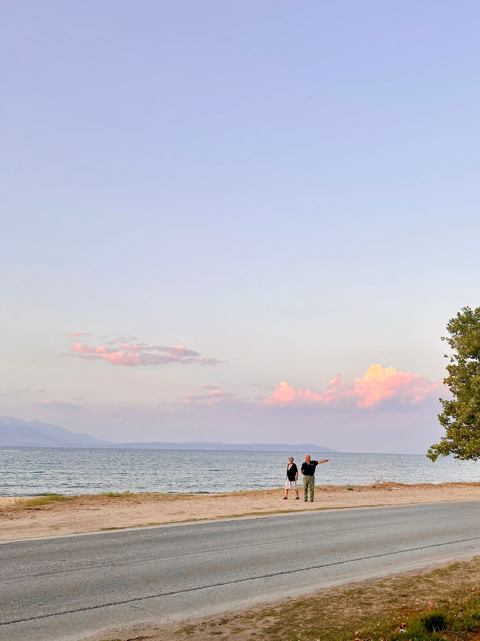 Couple walking by the beach at sunset