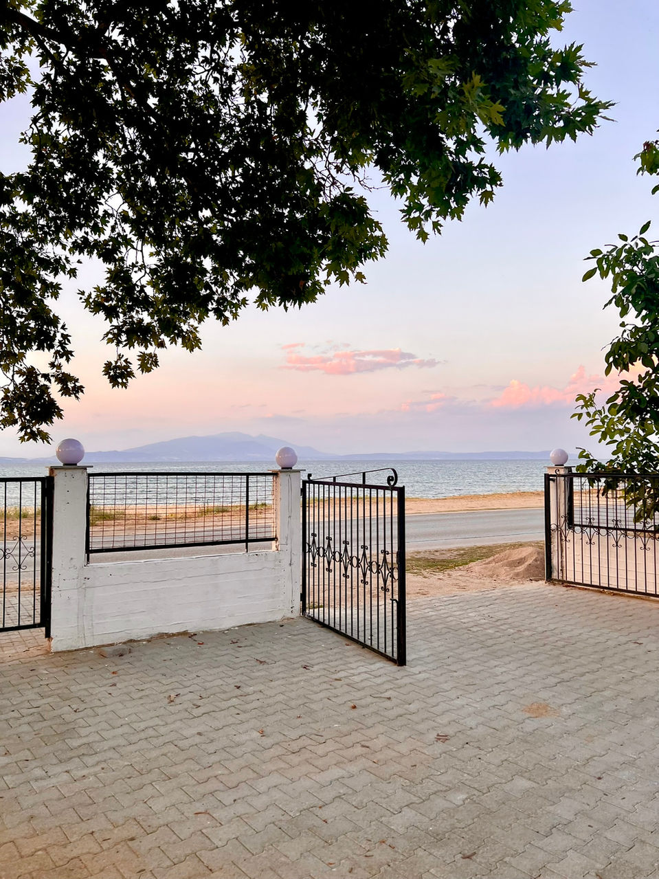 Open gate leading to beach at sunset