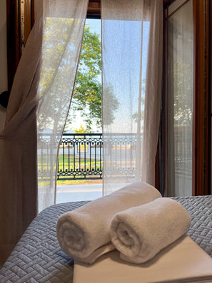 White towels on bed, balcony view