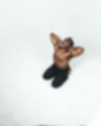 a topless man in black pants sitting in a white background holding his head and screaming - Photo by mwangi gatheca on Unsplash