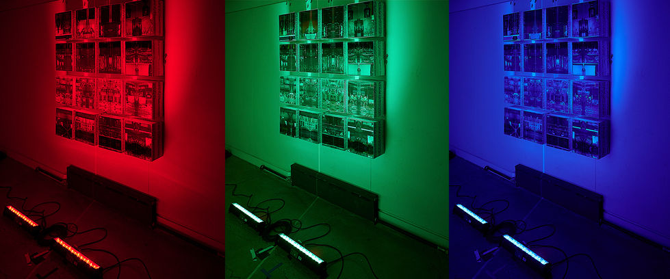 Three colored photograph of a video installation piece entitled The Gift by Haoyu Zhao.
In the images, the boxes are illuminated by RGB light. Inside the boxes, there are superimposed images featuring landmarks, sights, and crowds from New York City.