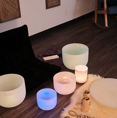 Sound Bath set up showing a variety of hand instruments and frosted quartz crystal singing bowls