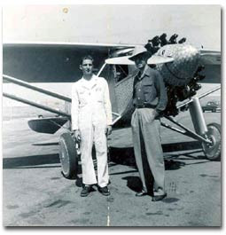 Image of two men standing in front of a replica of the Spirit of Saint Louis Plane