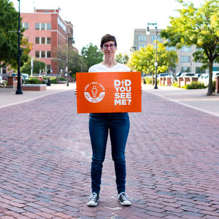 Holly holds a Look.See.Save. sing saying "Did you see me?"