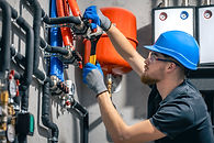 man-installs-heating-system-house-checks-pipes-with-wrench.jpg