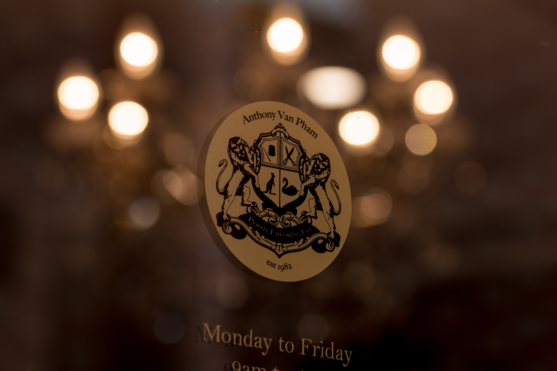 Perth Tailoring Co family crest displayed against chandelier lighting