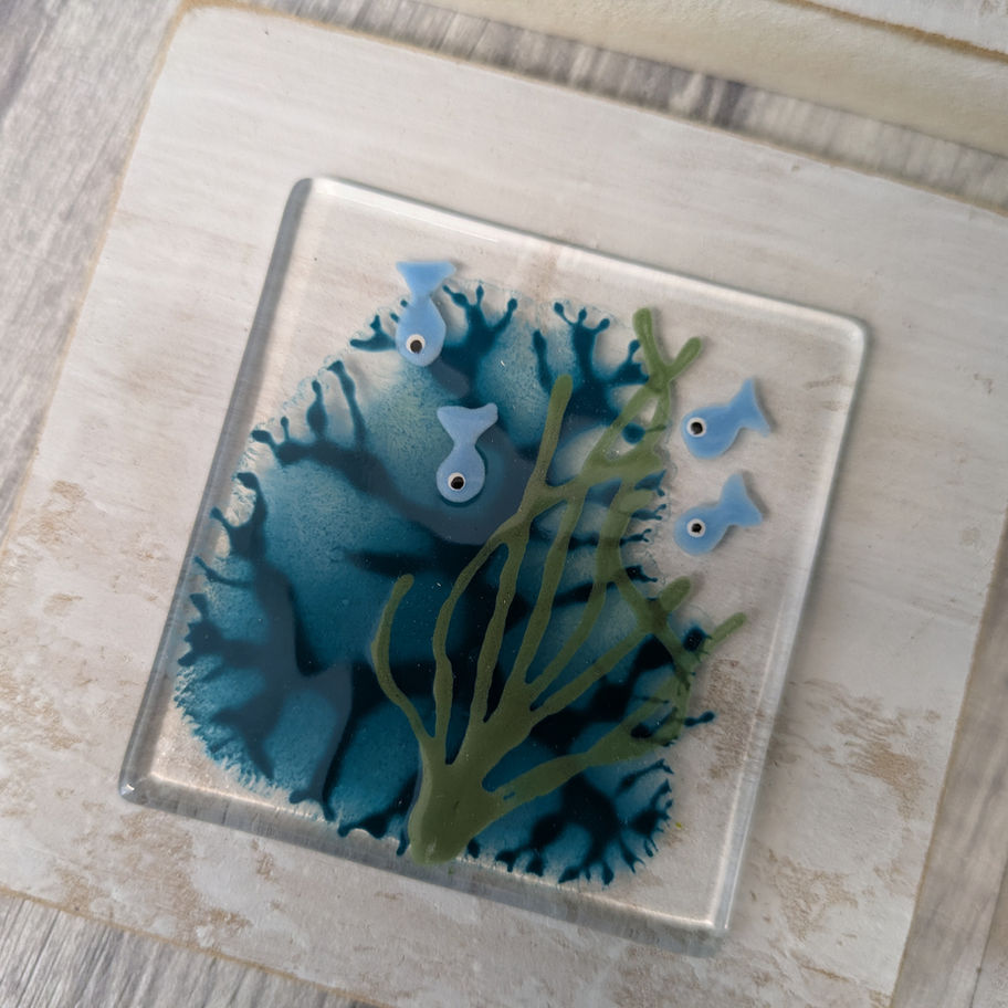 Glass art with aquatic life and blue accents, in a wooden frame