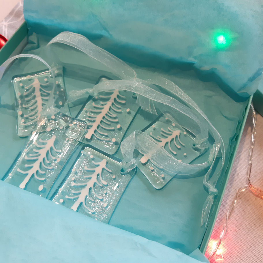 Pack of Two Fused Glass Christmas Tree Decorations, clear glass, ribbon, turquoise background.