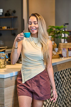Guest enjoying a latte in a blue cup inside Carmela Coffee café