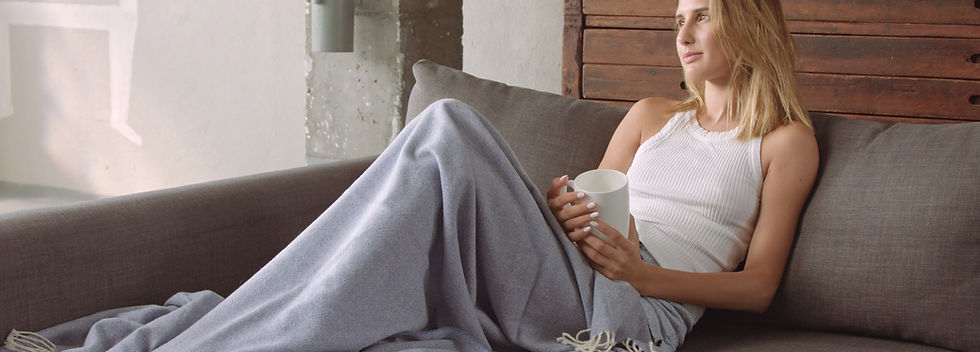 beautiful-female-model-couch-with-cup-coffee-blue-blanket-looking-camera-then-going-back-h