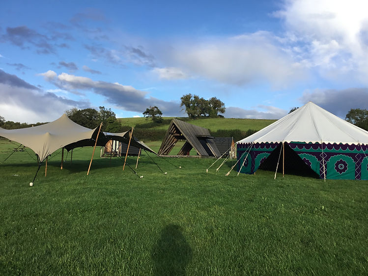 Tents for events set up on a grass field for a wedding. Colourful event tent.