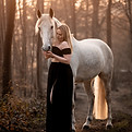 Frau mit Pferd bei Sonnenuntergang im Wald – inniger Moment voller Vertrauen