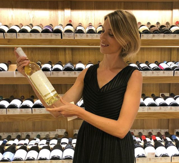 Margot présentant une bouteille de Sauvignon blanc bordelais