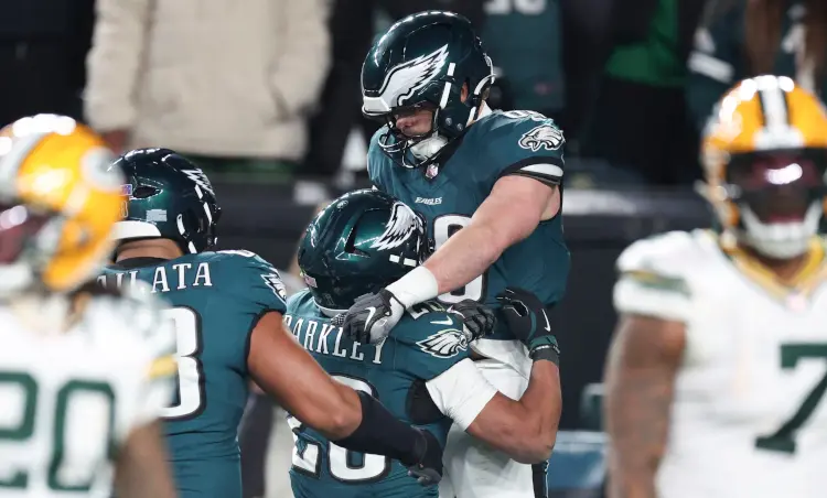 Eagles running back Saquon Barkley celebrates with Dallas Goedert after the tight end scored a touchdown in the third quarter against Green Bay.
David Maialetti