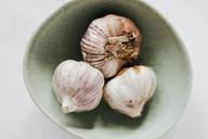 Dried garlic bulbs in a bowl.