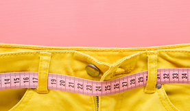 Person wearing green pants with a hat over their knees