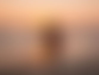 Woman enjoying a serene sunset by the sea, representing peace, mindfulness, and burnout recovery for neurodivergent adults.