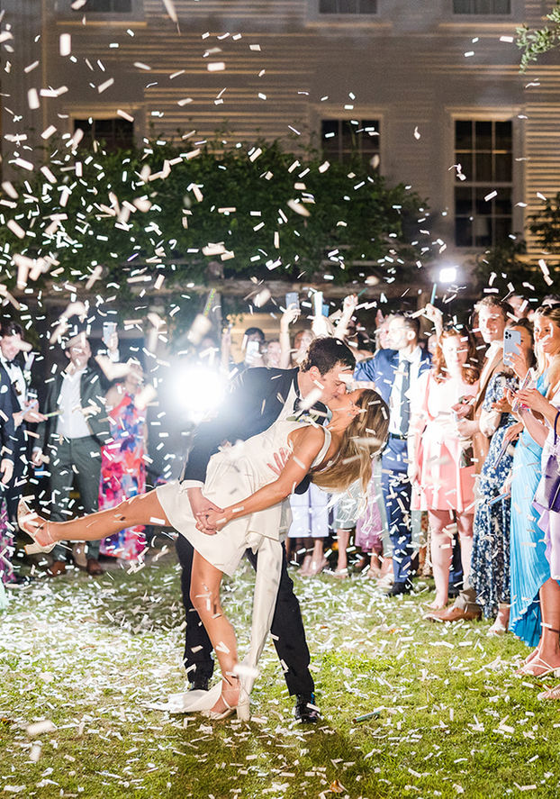 Confetti cannon wedding sendoff with the bride and groom celebrating outdoors at Wavering Place.