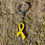 Miniature : Porte-clé en métal argenté avec le ruban jaune émaillé, symbole de l'endométriose.
