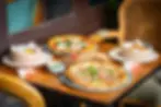 Best pizza in Bangkok, Thailand served at Massilia restaurant — featuring artisanal Neapolitan-style pizzas, fresh appetizers, and rustic bread on a cozy wooden table setting
