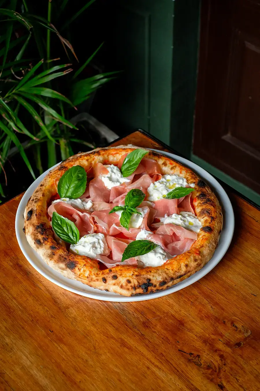 Neapolitan pizza topped with culatello, fresh burrata and basil at Massilia Bangkok
