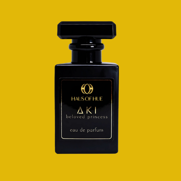 A luxurious black perfume bottle with gold accents, labeled 'Haus of Hue AKI Beloved Princess Eau de Parfum,' isolated on a black background.