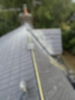 Local roofers installing new tiles on a house rooftop.