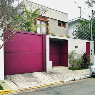 Fachada branca com detalhes em fúcsia vibrante, criando um contraste moderno e chamativo.