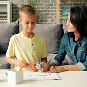 Young family mom and son are drawing wit