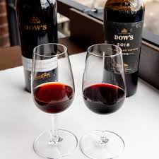 בקבוקי יין פורט טוני ורובי על חבית עץ במרתף יין בפורטו פורטוגל