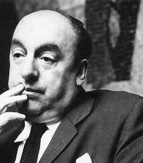 Poet Pablo Neruda holds his hand to his lips while wearing a suit and tie.