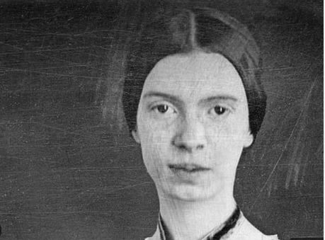 A woman in a dark 19th-century dress sits with a composed expression. The background is plain, and the image is in black and white.