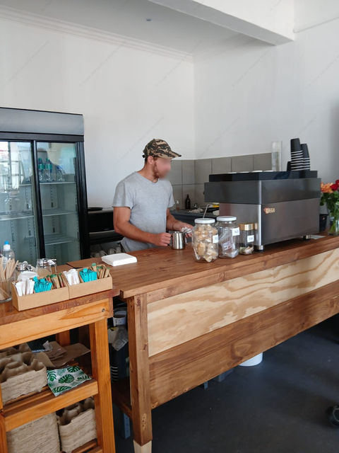 Barista at work behind the coffee counter, Cape Art Gallery Muizenberg.