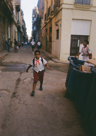 niño con uniforme escolar caminado por la calle.