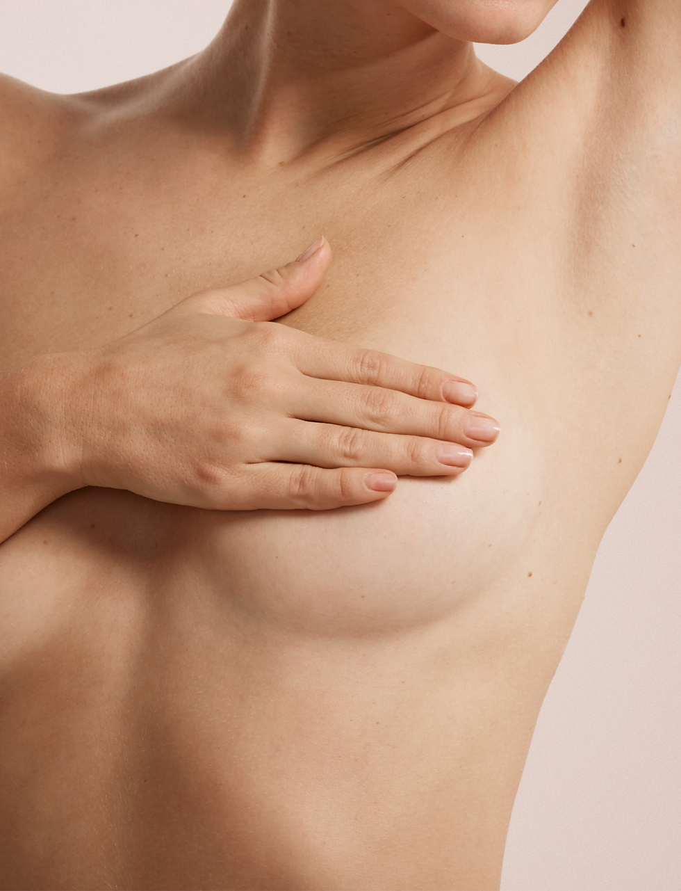 Closeup cropped portrait young woman with breast pain touching chest colored isolated on b
