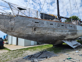 Twin keel steel sailboat ground down to bare metal to treat rust.