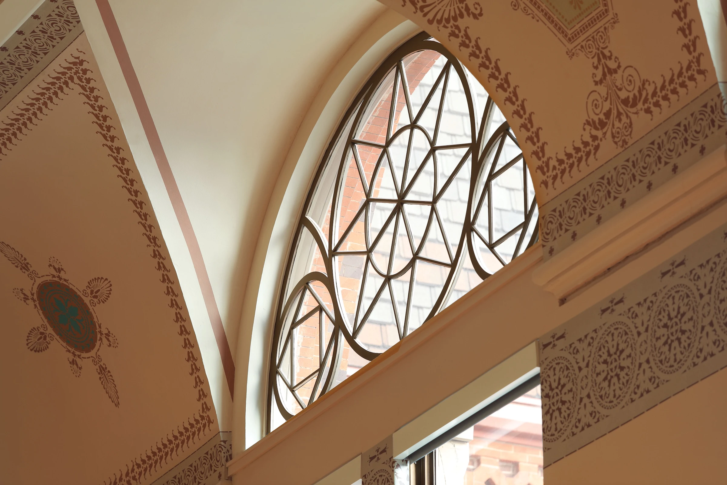 Ornamental arched transom window with unique detailing at commercial heritage property